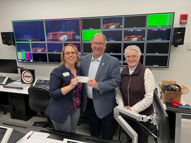 Bill Hubbard (center) and Eileen Mach (wife of the late Gary Mach, right) present a donation to Joy Wick, Executive Director of Advancement, UW Green Bay (left).
